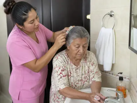 Cuidadora auxiliando idosa nos cuidados de higiene